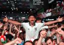 Fans celebrate following a screening of the FIFA World Cup match between England and Mexico at BOXPark Wembley in London
