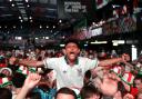 Fans celebrate following a screening of the FIFA World Cup match between England and Mexico at BOXPark Wembley in London
